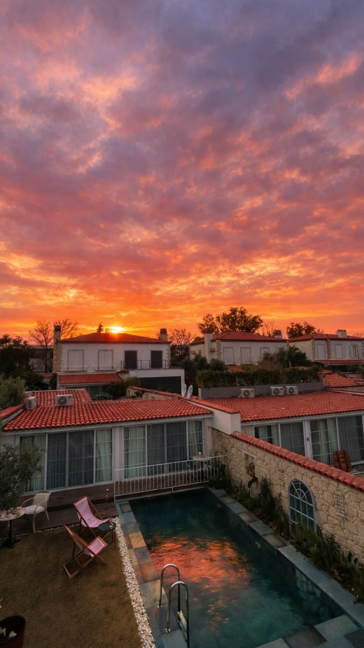 Noesta Alaçatı bahçesinde gün batımı — Çeşme yarımadası butik otel akşam manzarası