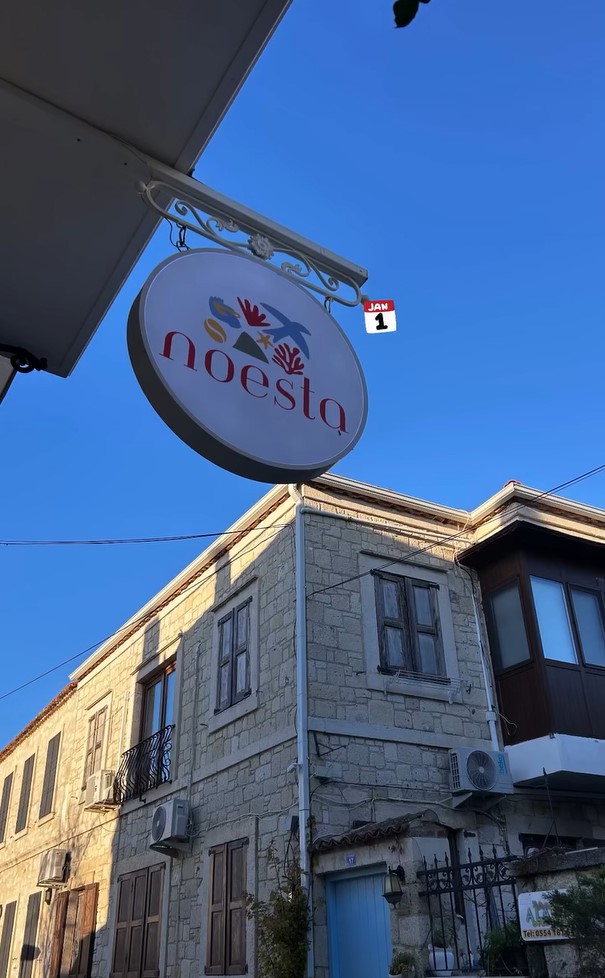 Noesta Alaçatı giriş kapısı ve tabelası — Turizm Bakanlığı tescilli lisanslı turistik pansiyon